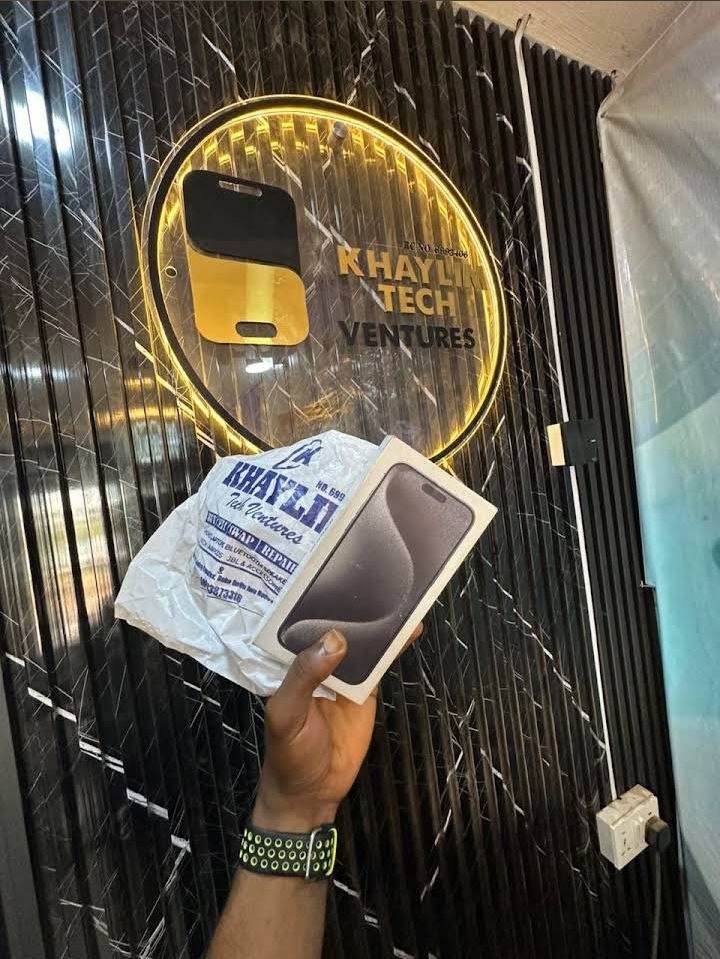 Official KhaylimTech branded bag and sealed iPhone box before gold store sign